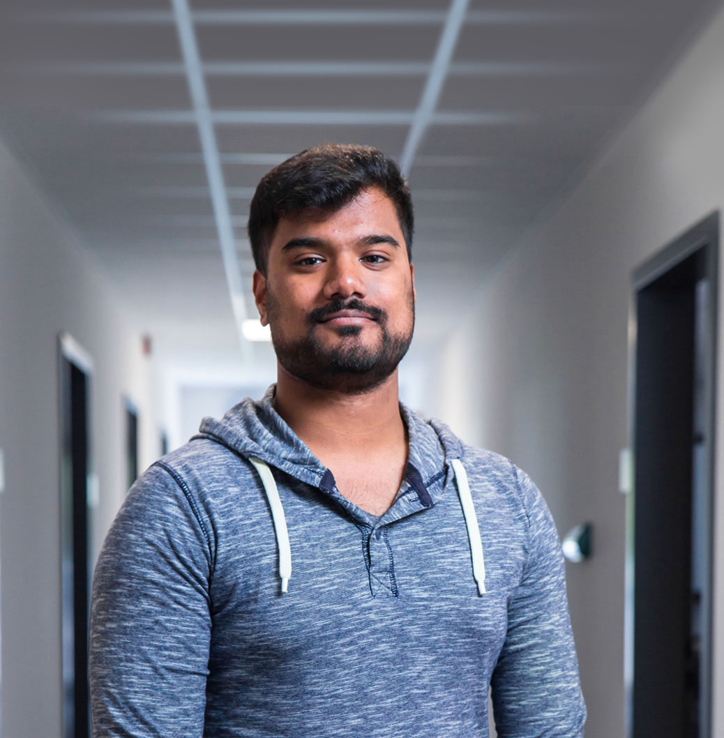 Das Bild zeigt einen jungen Mann mit Bart in einem Hoodie