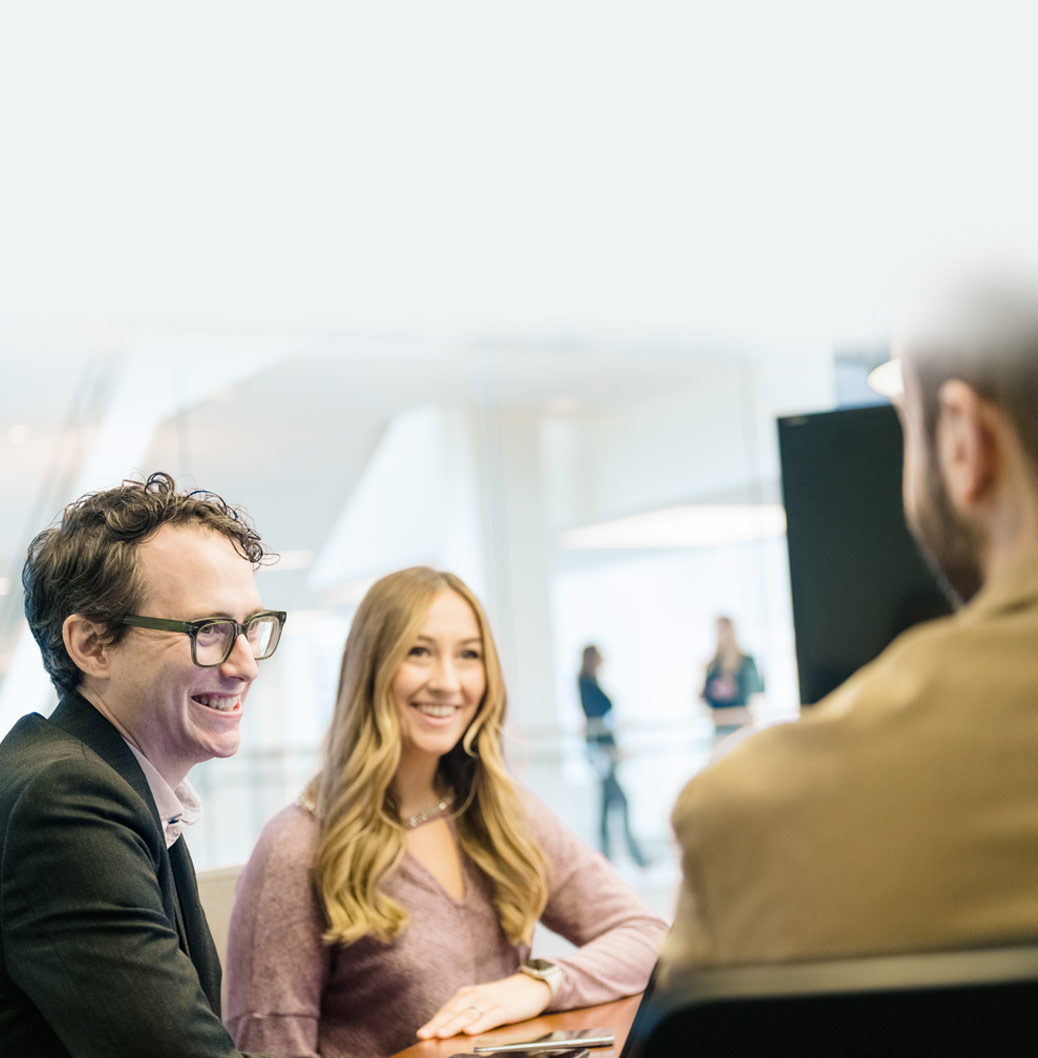 Das Bild zeigt Menschen, die sitzen und sich unterhalten, alle lächeln