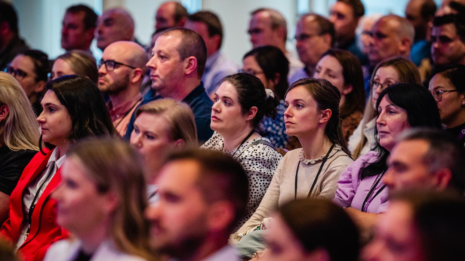 Das Bild zeigt Menschen, die in einem Auditorium sitzen.